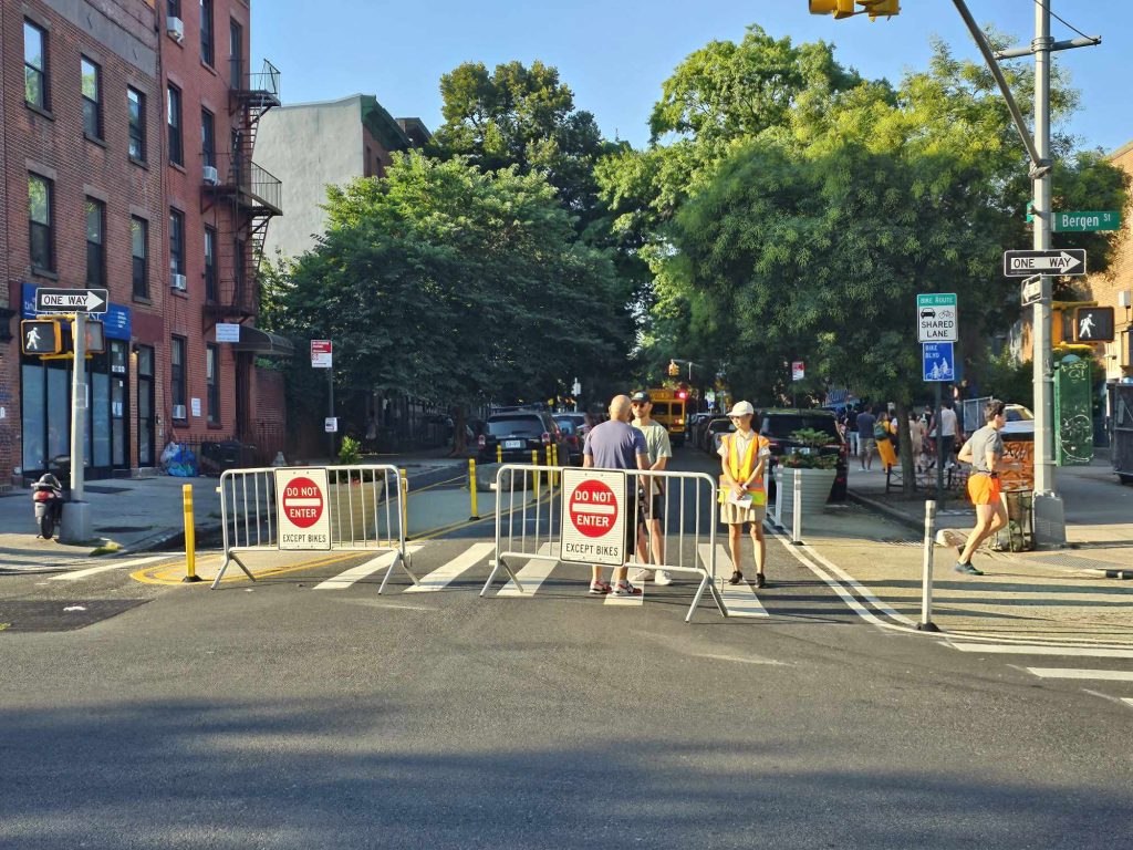 Underhill Avenue being barricaded with two Do Not Enter signs and people standing behind the barricades.