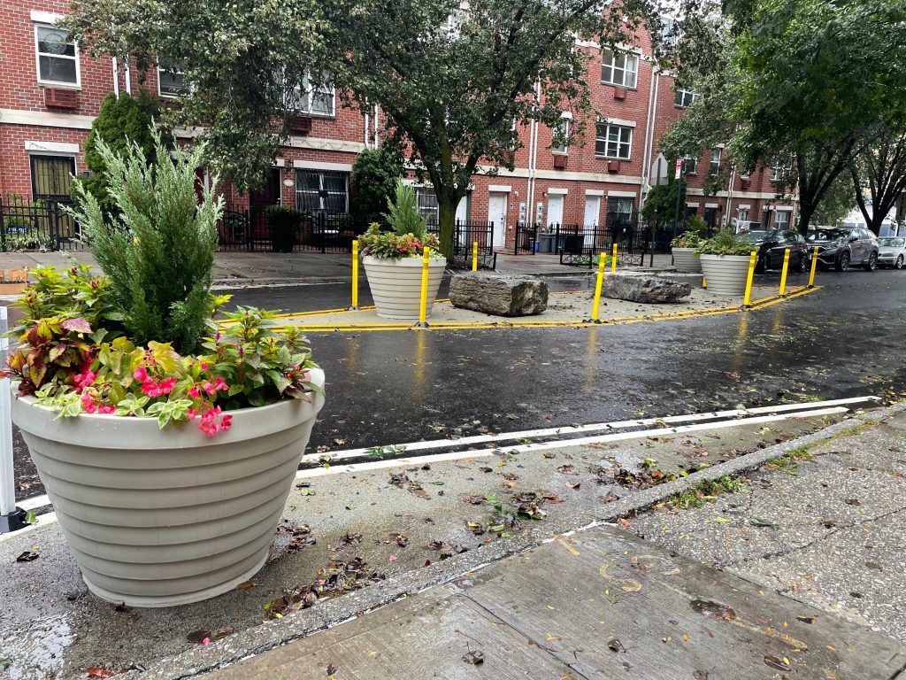 Underhill avenue island feature with large planters, boulders and bollards placed in the center of the street.